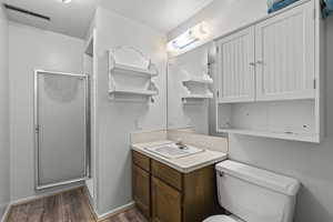 Bathroom with a stall shower, vanity, and dark wood-style floors
