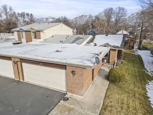 View of front facade featuring brick siding, a mountain view, asphalt driveway, and a garage