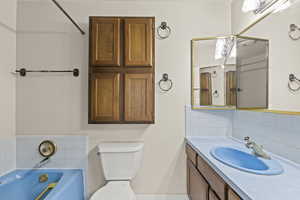 Full bath with tasteful backsplash, a garden tub, and vanity