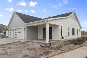 View of home's exterior with roof with shingles, driveway, and a garage
