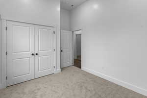 Unfurnished bedroom featuring light colored carpet and a closet
