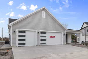 View of side of home with driveway and an attached garage