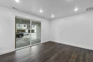 Spare room featuring dark wood-type flooring and recessed lighting