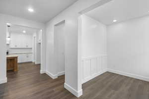 Hall featuring recessed lighting, dark wood-style floors, and wainscoting