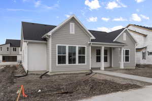 View of front of home featuring roof with shingles and a porch