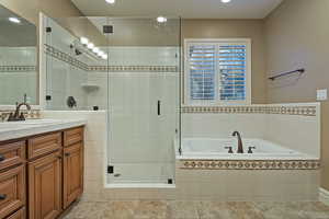 Full bath featuring vanity, a bath, a shower stall, and recessed lighting