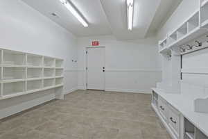 Mudroom featuring a textured ceiling and baseboards
