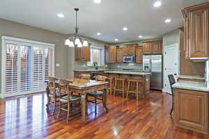Dining area with recessed lighting, dark wood-style flooring, and a chandelier