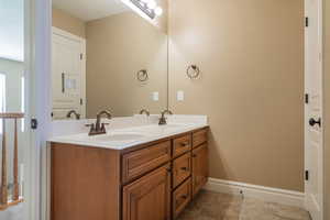 Bathroom featuring double vanity and baseboards