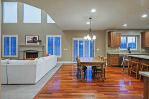 Dining space featuring a fireplace, dark wood-style flooring, recessed lighting, and a chandelier