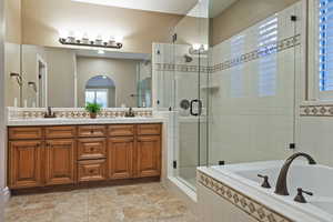 Full bath with double vanity, a bath, and a shower stall