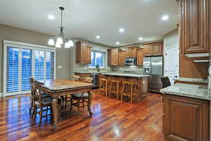 Dining room featuring dark wood-style floors, recessed lighting, and a chandelier