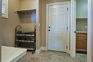 Mudroom featuring baseboards and stone tile flooring