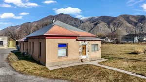 View of front of home with a mountain view, brick siding, and a front lawn