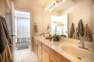 Bathroom featuring double vanity and light tile patterned flooring