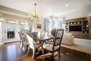 Dining room with dark wood finished floors, healthy amount of natural light, a chandelier, recessed lighting, and a textured ceiling