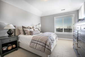 Bedroom featuring light carpet and baseboards