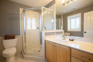 Full bath featuring a stall shower, vanity, and light tile patterned flooring