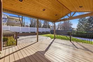 Stunning covered deck featuring a fenced backyard and salt water hot tub
