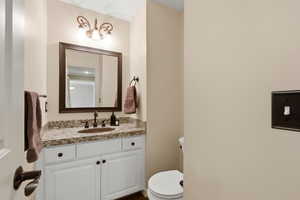 Bathroom with toilet and vanity right off of kitchen