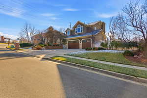 View of front of home with driveway, stucco siding, a garage, stone siding, and a residential view
