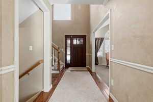 Entrance foyer featuring plenty of natural light, a high ceiling, dark wood finished floors, and stairway