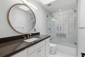 Bathroom featuring enclosed tub / shower combo and vanity