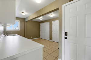Laundry room with natural  light,  tile patterned flooring,  baseboards and two huge pantry closets