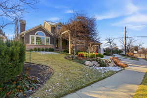 View of front of house featuring a front yard, a chimney, stucco siding, and driveway