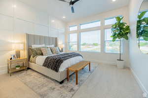 Carpeted bedroom with a decorative wall, ceiling fan, and recessed lighting