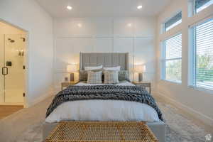 Carpeted bedroom with a decorative wall and recessed lighting