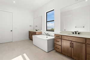 Bathroom with recessed lighting, two vanities, and a bathtub