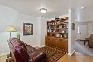 Living area featuring light wood-style floors and a textured ceiling