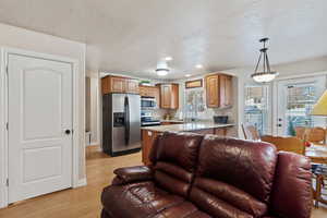 Living room featuring recessed lighting, light wood-style floors, and a textured ceiling