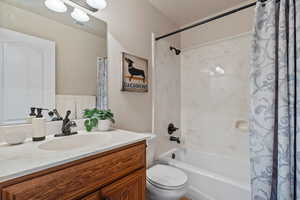 Bathroom with shower / bath combo with shower curtain and vanity