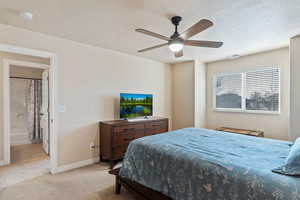 Carpeted bedroom with a textured ceiling and a ceiling fan