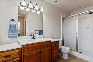 Bathroom featuring vanity, a marble finish shower, and light tile patterned flooring