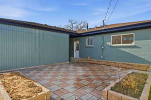 Back of property with a patio area and brick siding