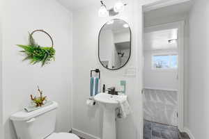 Half bathroom with toilet and baseboards