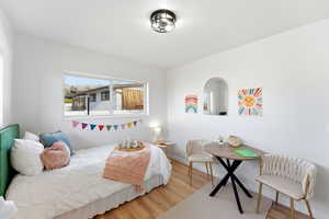 Bedroom featuring wood finished floors and baseboards