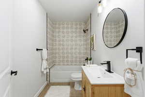 Bathroom featuring vanity, bathing tub / shower combination, and light wood-type flooring
