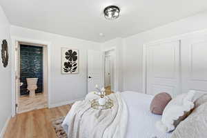 Bedroom featuring a closet, light wood-type flooring, and ensuite bathroom
