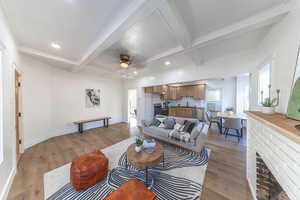 Living room with wood finished floors, coffered ceiling, beamed ceiling, ceiling fan, and recessed lighting