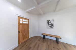 Entrance foyer with wood finished floors, coffered ceiling, and beamed ceiling