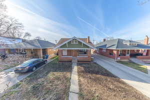 Bungalow-style house featuring a porch, brick siding, and driveway