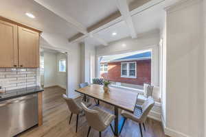 Dining area with coffered ceiling, beamed ceiling, light wood-style flooring, ornamental molding, and recessed lighting