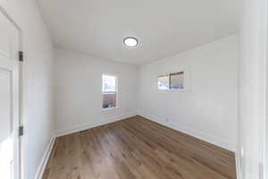 Unfurnished room with dark wood-type flooring and baseboards