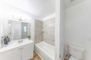 Full bath with vanity, shower / tub combination, and light wood-style flooring