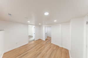 Finished below grade area with light wood finished floors and recessed lighting