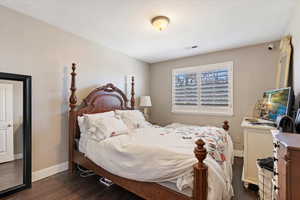 Bedroom featuring baseboards and dark wood-style flooring